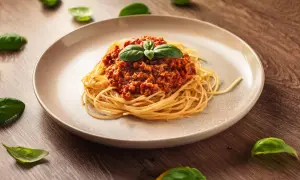 Pyszne spaghetti bolognese, idealne na prosty obiad. Aromatyczny sos mięsny z pomidorami i świeża bazylia na makaronie.