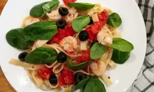 Szybki obiad dieta wątrobowa: makaron z krewetkami, pomidorami, oliwkami i szpinakiem. Lekkie i zdrowe danie.