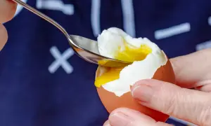 Łyżeczka wydobywa płynne żółtko z jajka na miękko. Zastanawiasz się, ile kalorii ma jajko na miękko? To zdrowa przekąska!