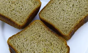Trzy kromki chleba orkiszowego na białym talerzu. Czy mąka orkiszowa ma gluten? Tak, orkisz zawiera gluten.