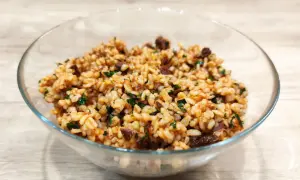 Sałatka z kaszą bulgur i suszonymi pomidorami, pełna smaku i ziół, w szklanej misce.