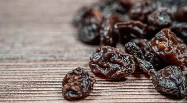 Garść rodzynek na drewnianym tle. Zastanawiasz się nad rodzynki kcal?