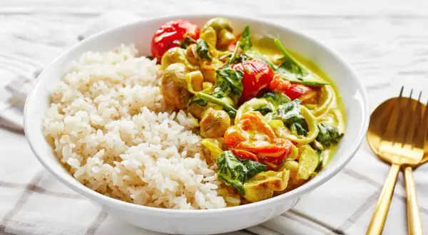 Pyszne dania na ciepło bez mięsa: ryż z aromatycznym curry warzywnym, pomidorkami i szpinakiem.