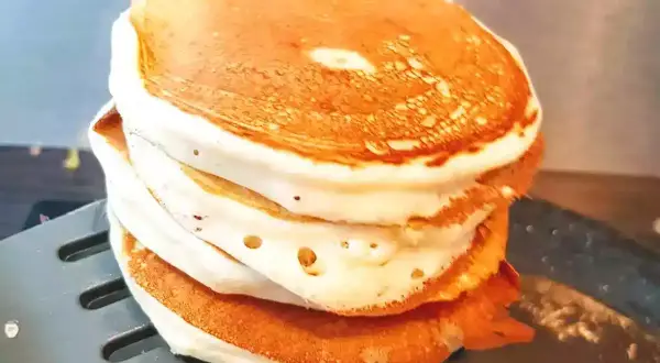 Stos puszystych naleśników proteinowych na łopatce.