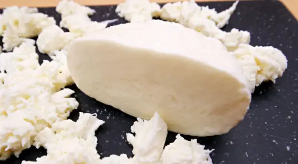 Kawałek mozzarelli light, otoczony postrzępionymi kawałkami sera. Idealna do lekkich sałatek, niskokaloryczna przyjemność.