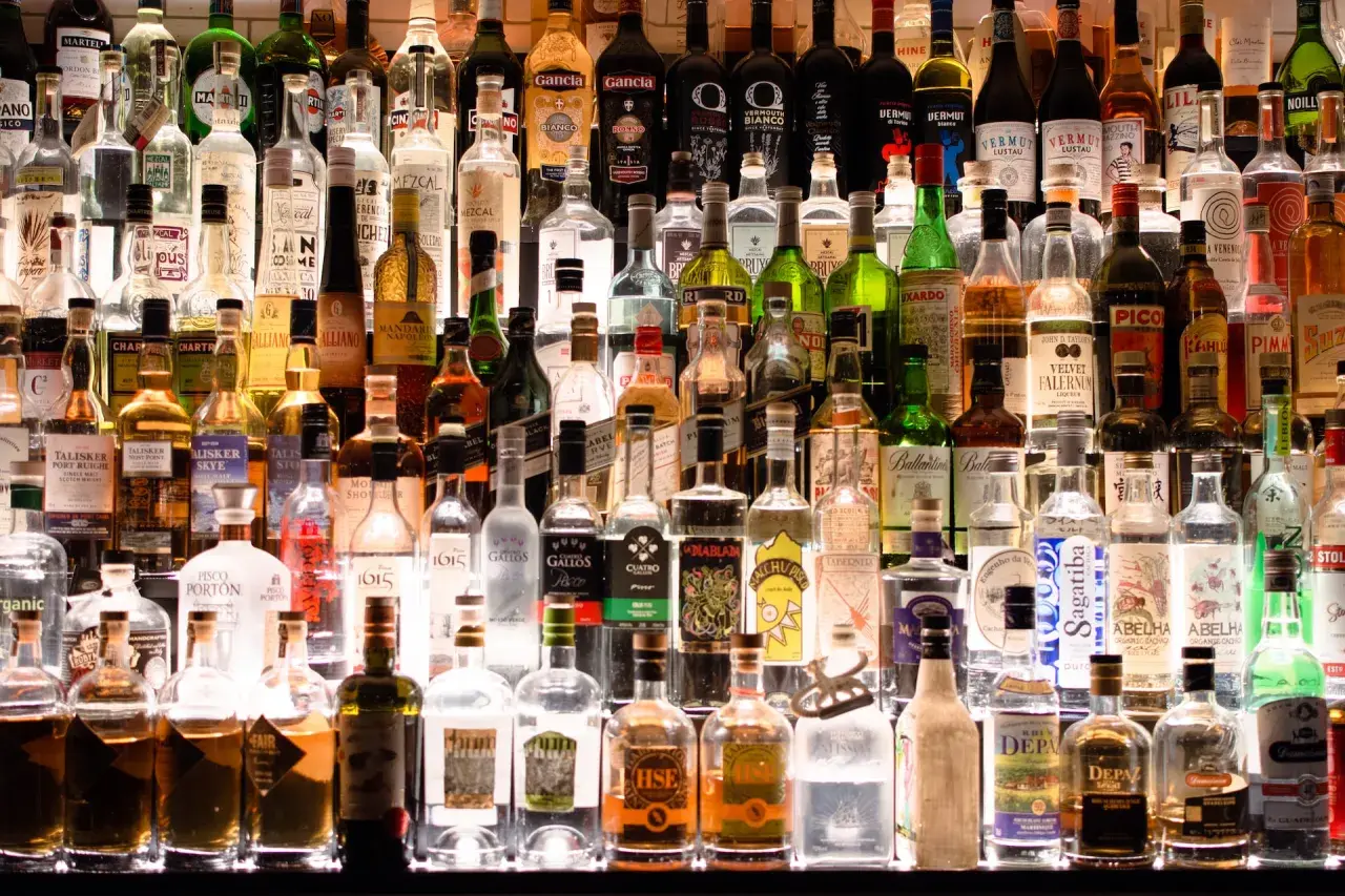 Wiele butelek alkoholu na półce. Szukając, jaki alkohol ma najmniej kalorii, warto zwrócić uwagę na te przejrzyste.